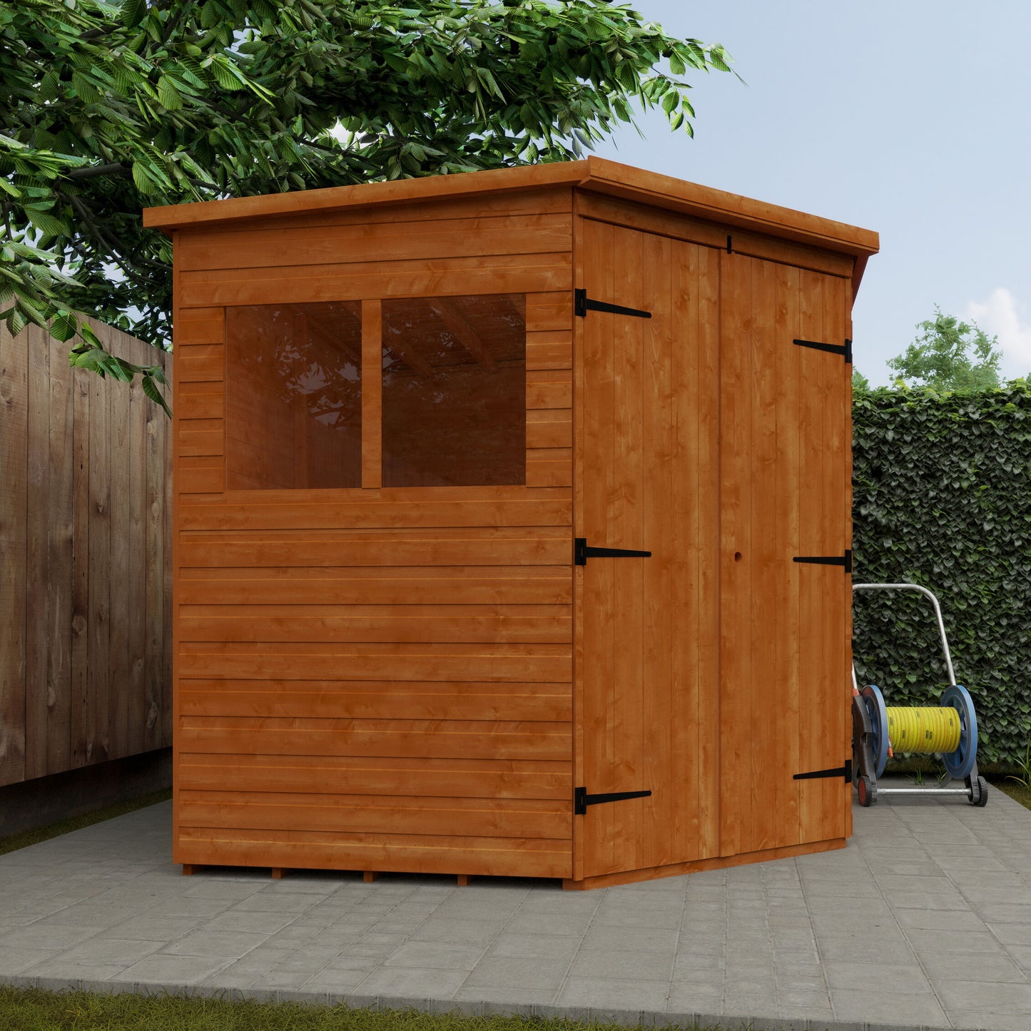 Wooden shed with a door and window on a paved area with greenery in the background